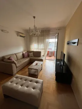 Living room with a sectional sofa, TV, and access to the balcony. - image 9