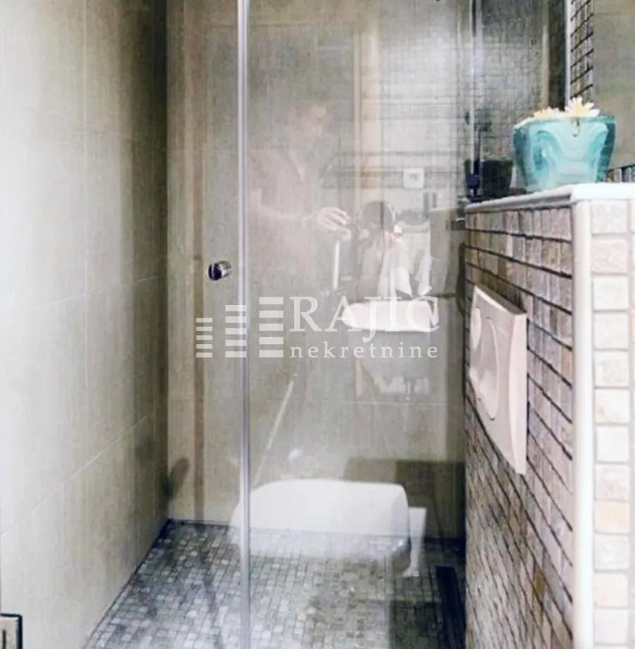Modern bathroom with a walk-in shower and mosaic tiles.