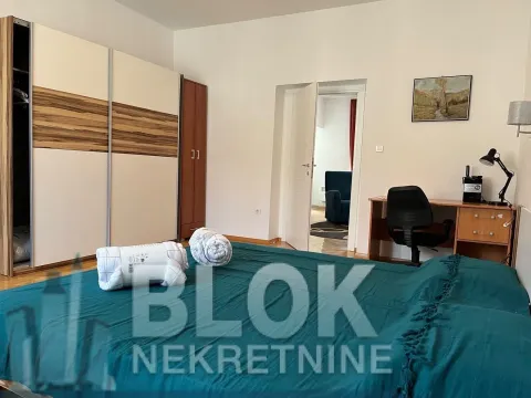 Namještena spavaća soba sa velikim bračnim krevetom, plakarom i radnim stolom. - image 4
