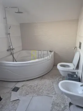 Bathroom with a built-in corner bathtub, toilet, and bidet. - image 7