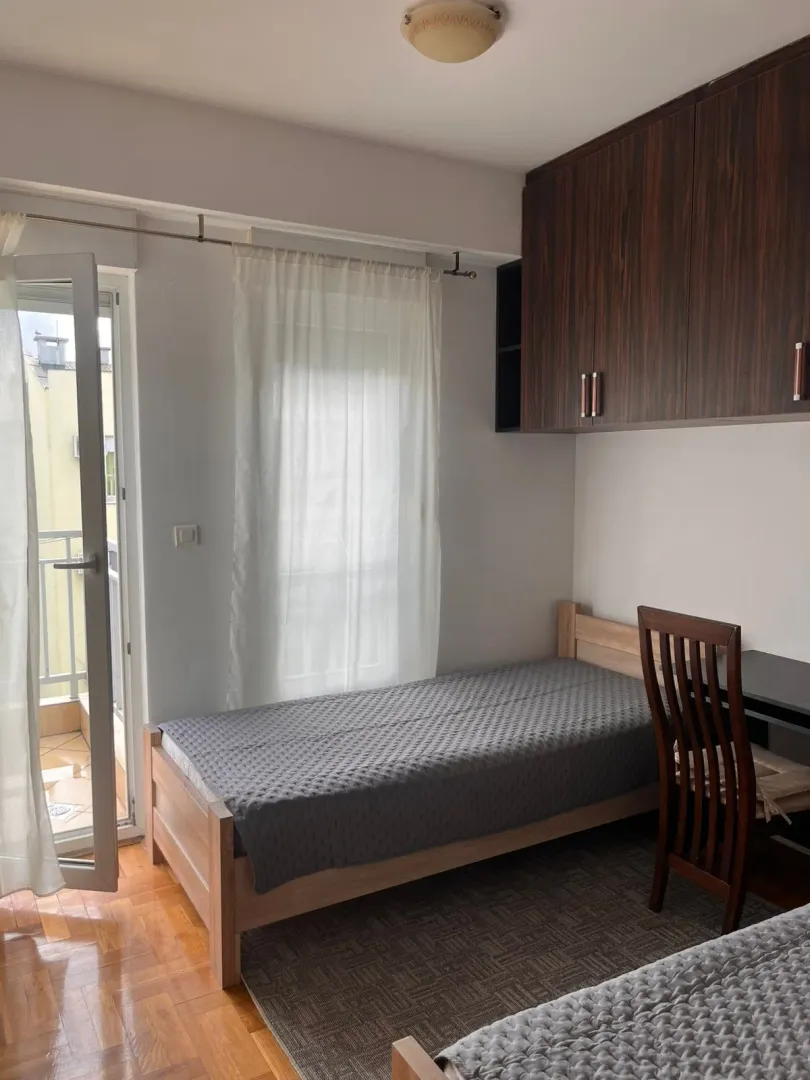 Furnished bedroom with a bed, desk, and access to the terrace.