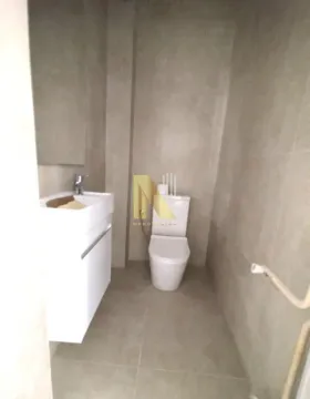 Small bathroom with a sink and toilet in grey tile finish. - image 19