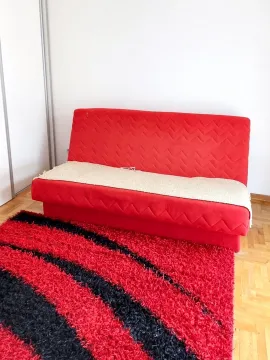Dnevna soba sa crvenim kaučem i tepihom. - image 3