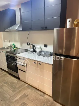 Kitchen with white lower units, dark upper cabinets and a stainless steel refrigerator. - image 8