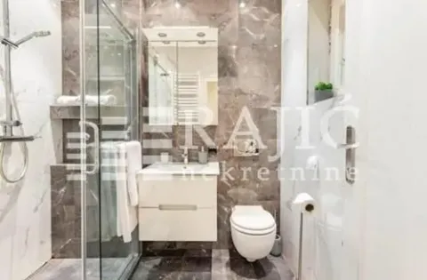 Modernly equipped bathroom with a walk-in shower and marble tiles. - image 12