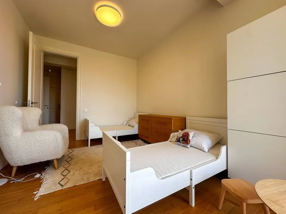 Dječja spavaća soba sa dva kreveta, foteljom i garderoberom.