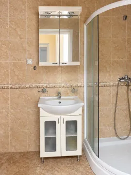 Bathroom equipped with a vanity unit with sink, mirror, and a shower cabin. - image 8