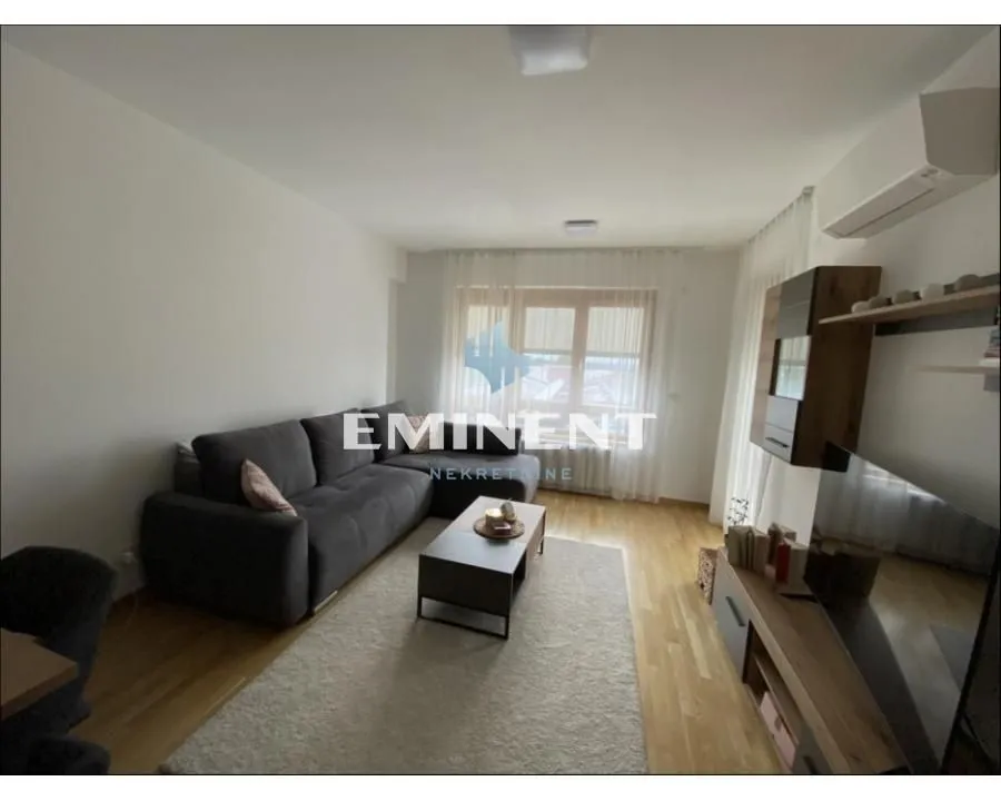 Living room with a corner sofa, coffee table and TV.