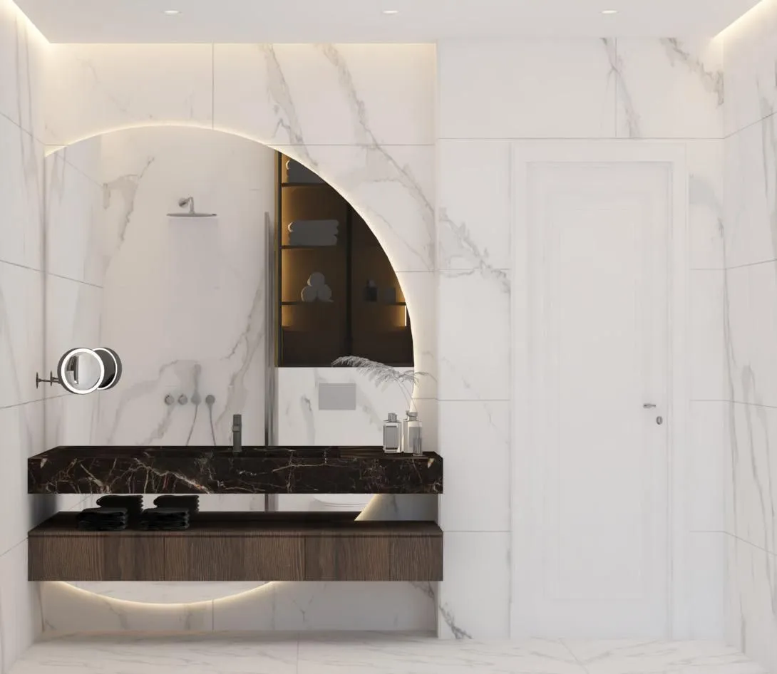 Moderno opremljeno kupatilo sa mermernim pločicama i velikim okruglim ogledalom.
