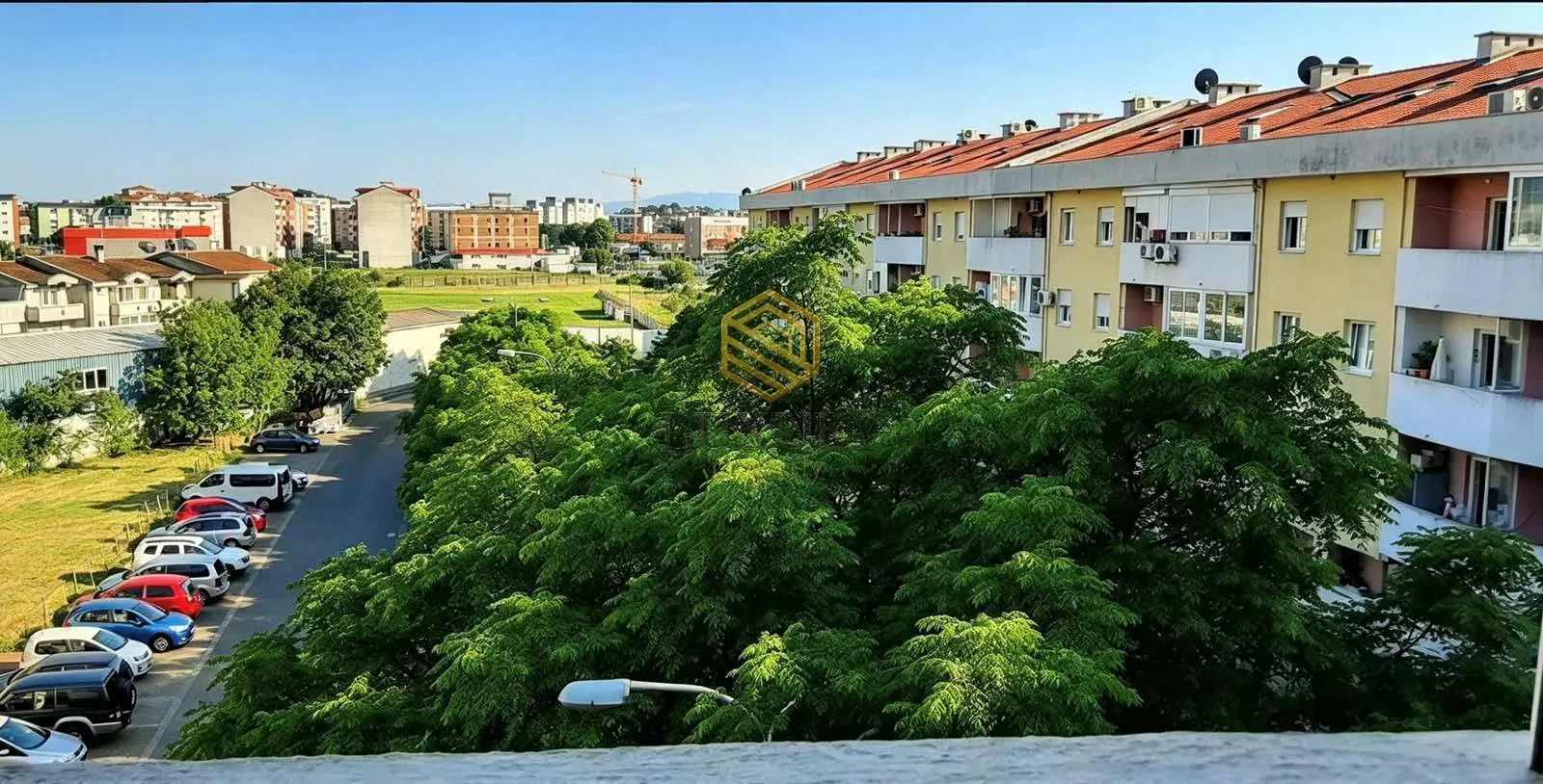 Pogled sa terase na naselje i zelenilo.