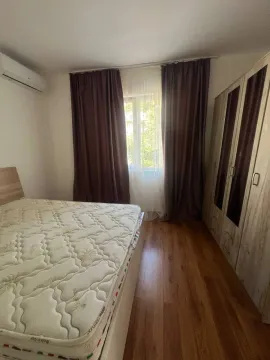 Bedroom with a bed, wardrobe, and a window with curtains. - image 9