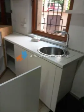 Small kitchen with a sink under the window and white cabinets. - image 10