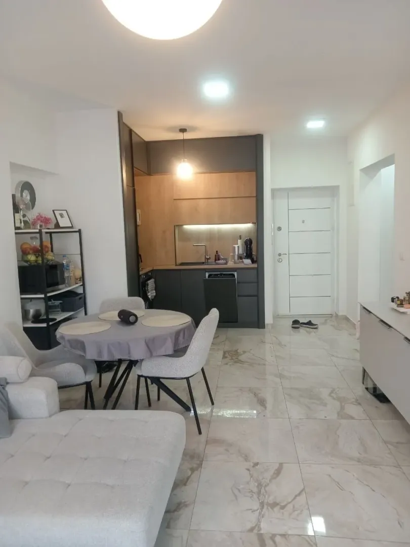 Living room with dining area and kitchen in the background.