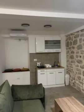 Small living room with a kitchenette and a sofa in the foreground. - image 3