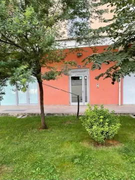 Building entrance with a green lawn in front. - image 12