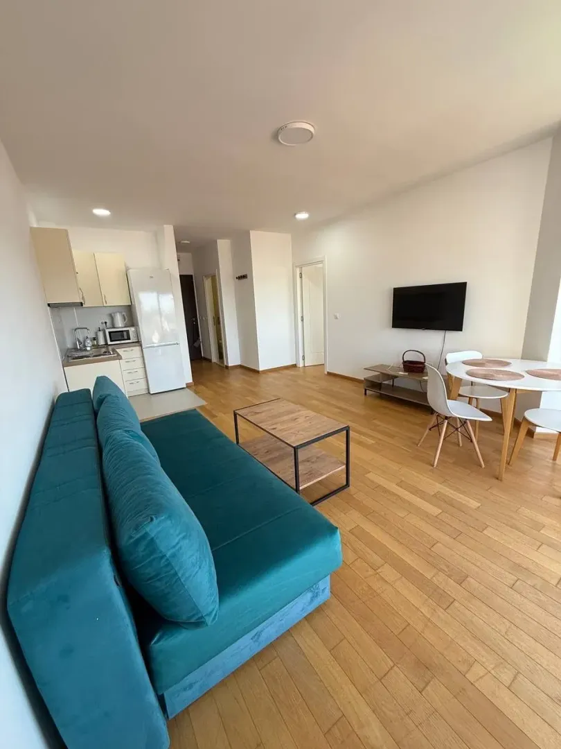 Living room with sofa, dining area, and connected kitchen.
