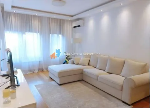 Living room with a sectional sofa, TV, and large windows. - image 4