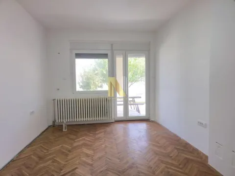 Prazna soba sa parketom, belim zidovima i izlazom na terasu. - image 8