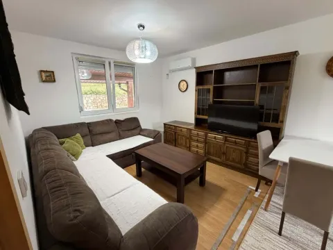 Living room with a sectional sofa, a large wooden cabinet, a television, and a dining table. - image 2