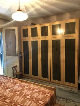 Spavaća soba sa velikim drvenim ormarom i krevetom. - image 21