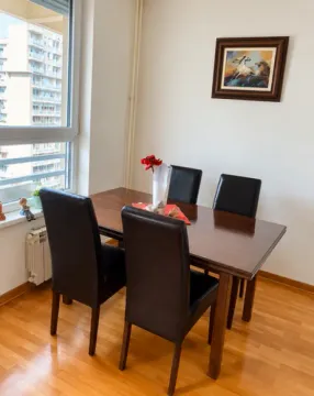 Dining area with a wooden table and black chairs near the window. - image 10