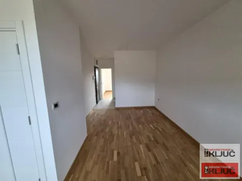 Prazna soba sa parketom i belim zidovima u stanu. - image 9