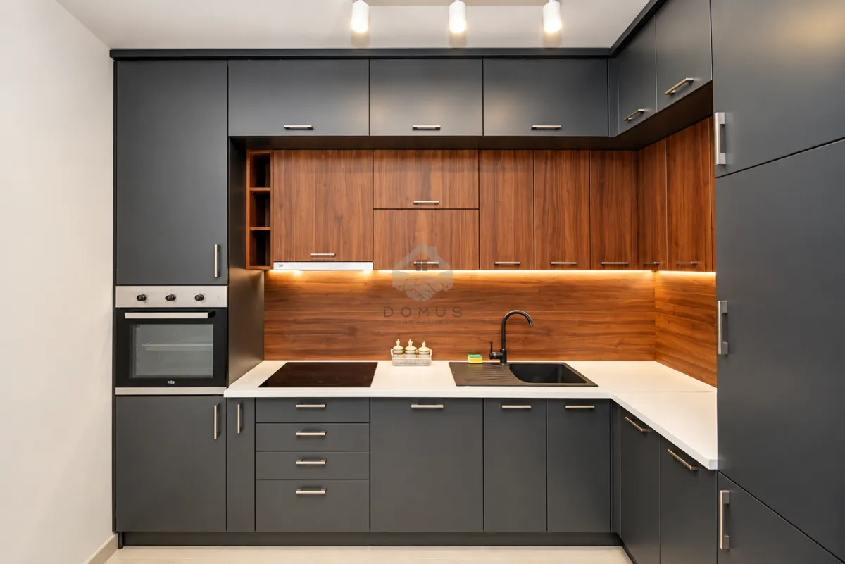 Modern kitchen with dark cabinets and wooden details.