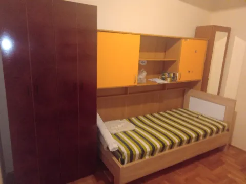 Spavaća soba sa jednokrevetnim krevetom i ormarom. - image 4