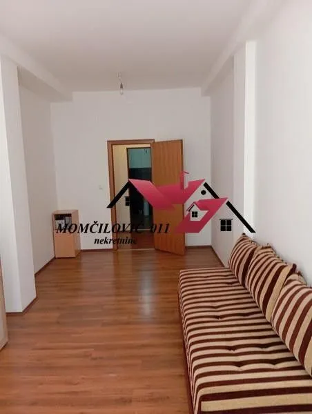 Living room with a sofa and laminate flooring.