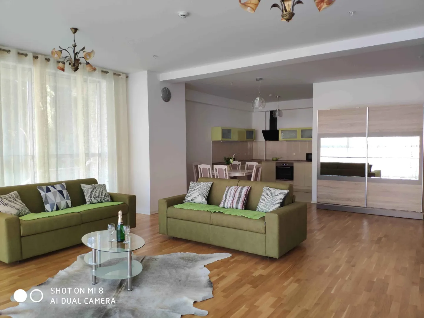 Bright living room with green sofas.