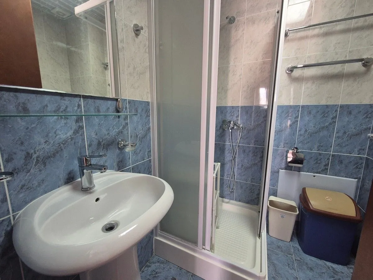 Bathroom with a sink and a shower cabin.