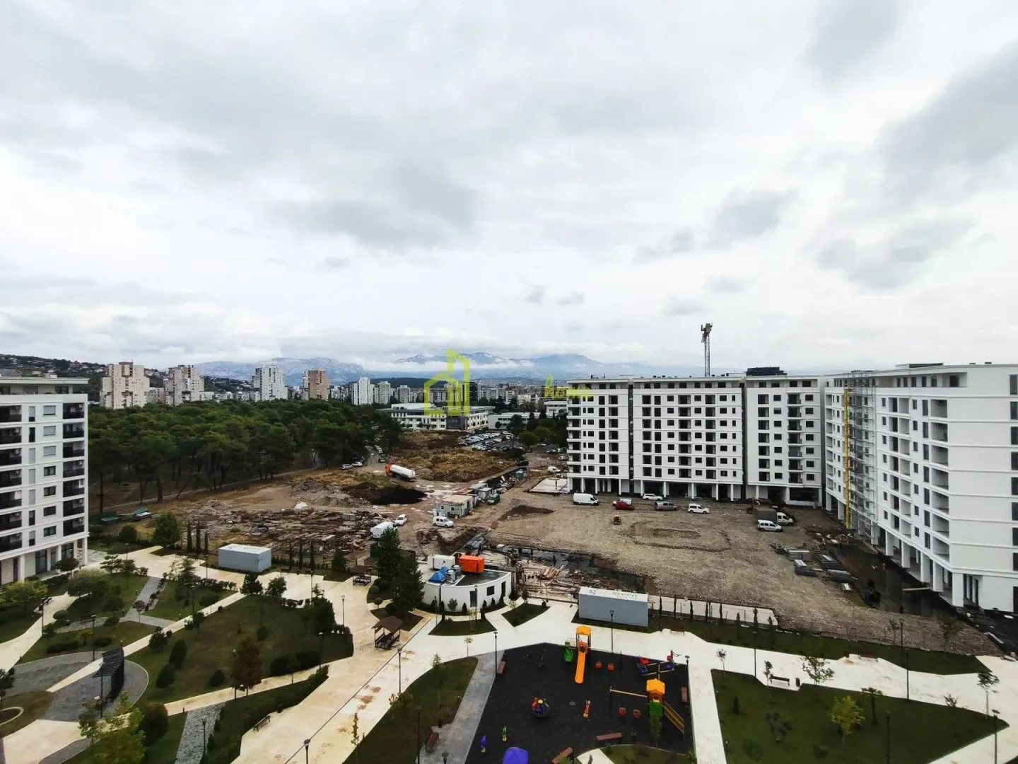 View from the apartment overlooking the building's courtyard, playground, and surrounding neighborhood under construction.