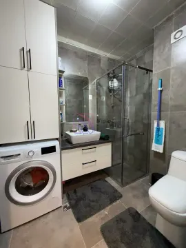 Kupatilo opremljeno tuš kabinom, umivaonikom, WC šoljom, mašinom za veš i ormarićem. - image 7