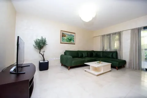 Dnevna soba sa zelenom ugaonom garniturom, stočićem i televizorom. - image 2