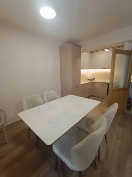 Trpezarija sa bijelim stolom i stolicama, sa pogledom na kuhinjski dio. - image 4