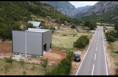 Aerial view of a building under construction next to a road and mountain landscape. - image 6