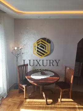 Dining area with a wooden table and chairs in an apartment. - image 9