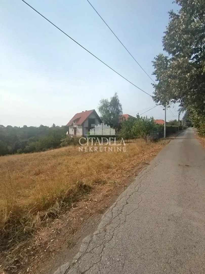 Asfaltni put pored placa i kuće u izgradnji.