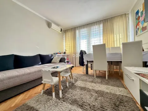 Dnevna soba sa garniturom za sedenje, trpezarijskim stolom i tepihom. - image 2