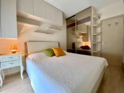 Furnished bedroom with a double bed, wardrobe, and wall-mounted storage. - image 9