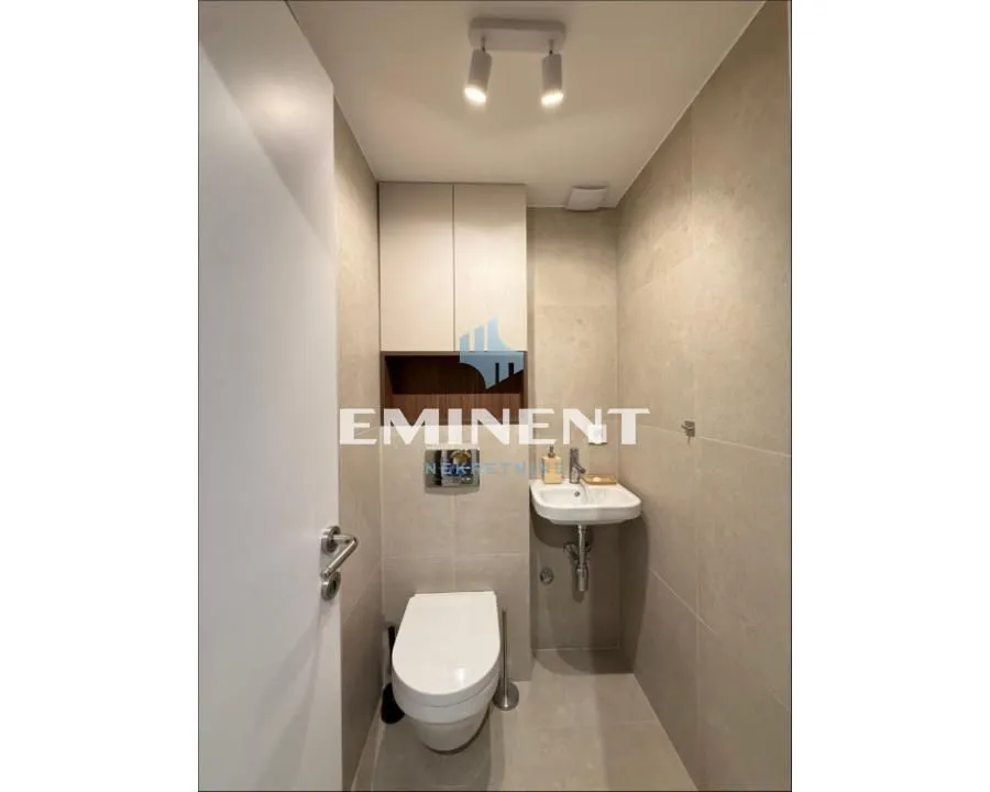 Smaller modern bathroom with toilet, washbasin, and built-in cabinetry.