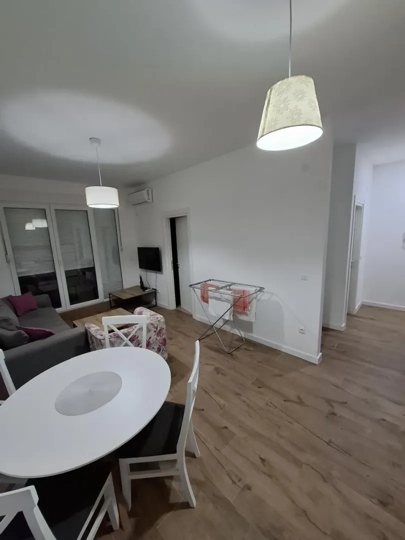 Living room with dining area and a clothes drying rack in the corner.