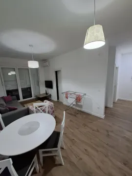 Living room with dining area and a clothes drying rack in the corner. - image 4
