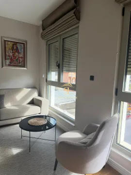 Svijetao dnevni boravak sa garniturom za sjedenje i velikim prozorima. - image 9