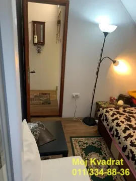 Manja spavaća soba sa krevetom, podnom lampom i pogledom na hodnik. - image 18