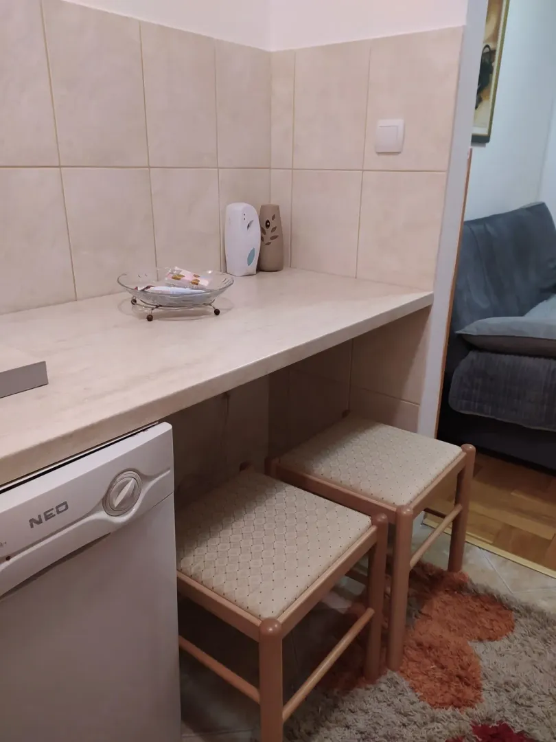 A kitchen counter with two bar stools and a household appliance.