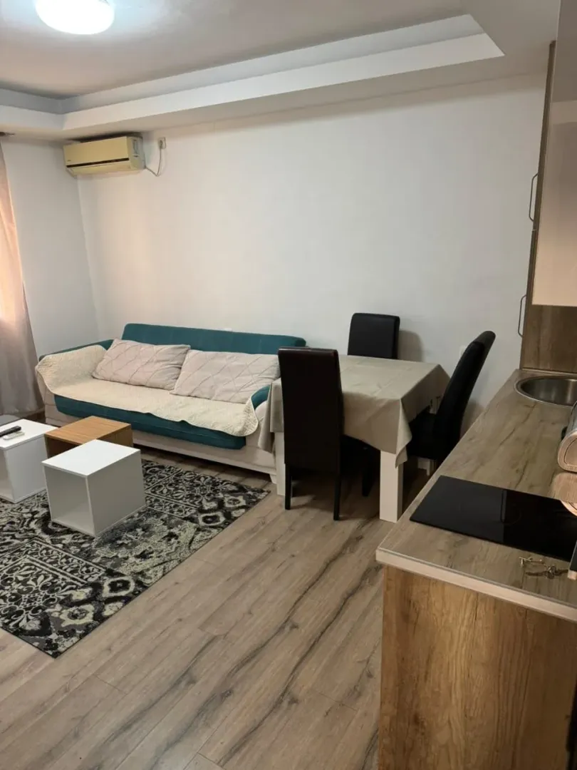 Living room with a sofa, dining table, and kitchen units.
