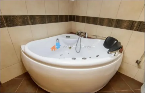 Bathroom equipped with a corner whirlpool bathtub and brown toned tiles. - image 20