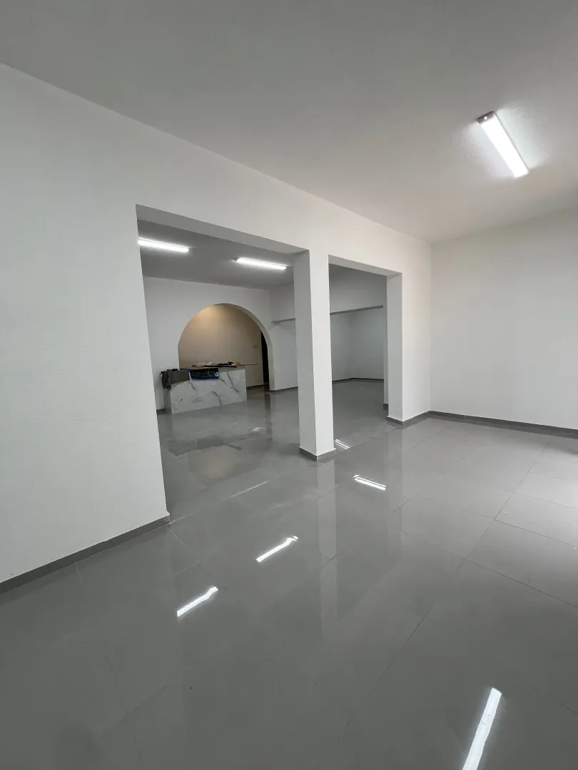 Empty bright room with tiled flooring and pillars.