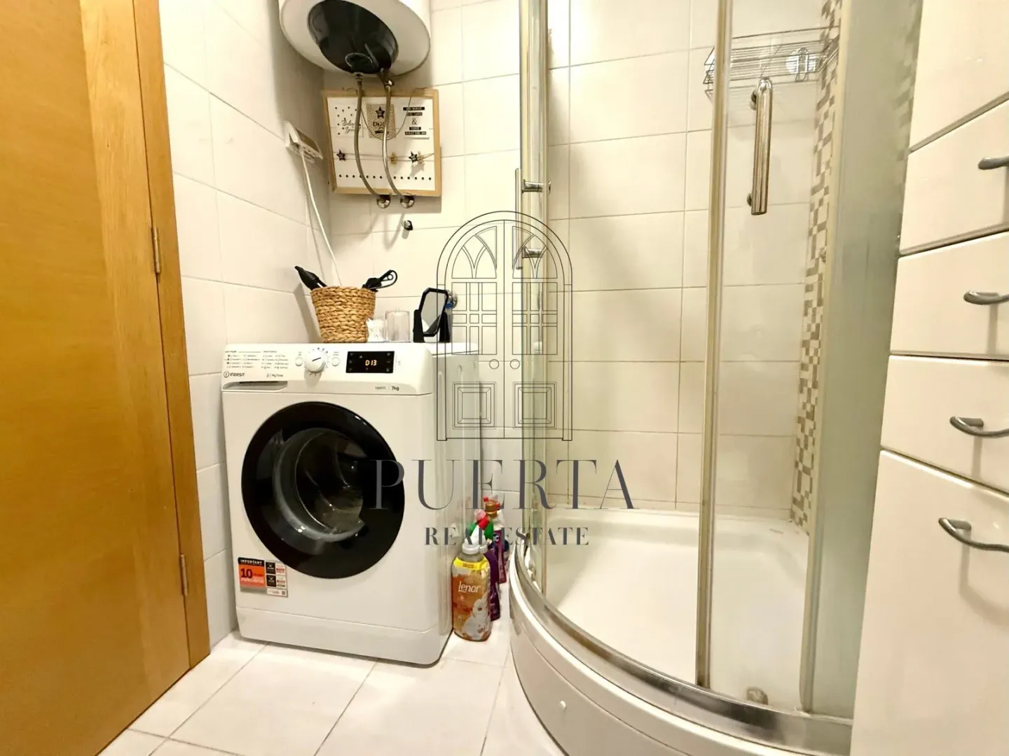 Small bathroom with a shower cabin and a washing machine.
